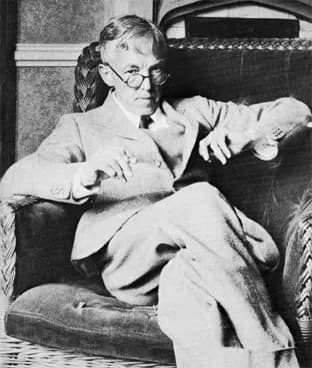 G. H. Hardy, seated in a wicker chair